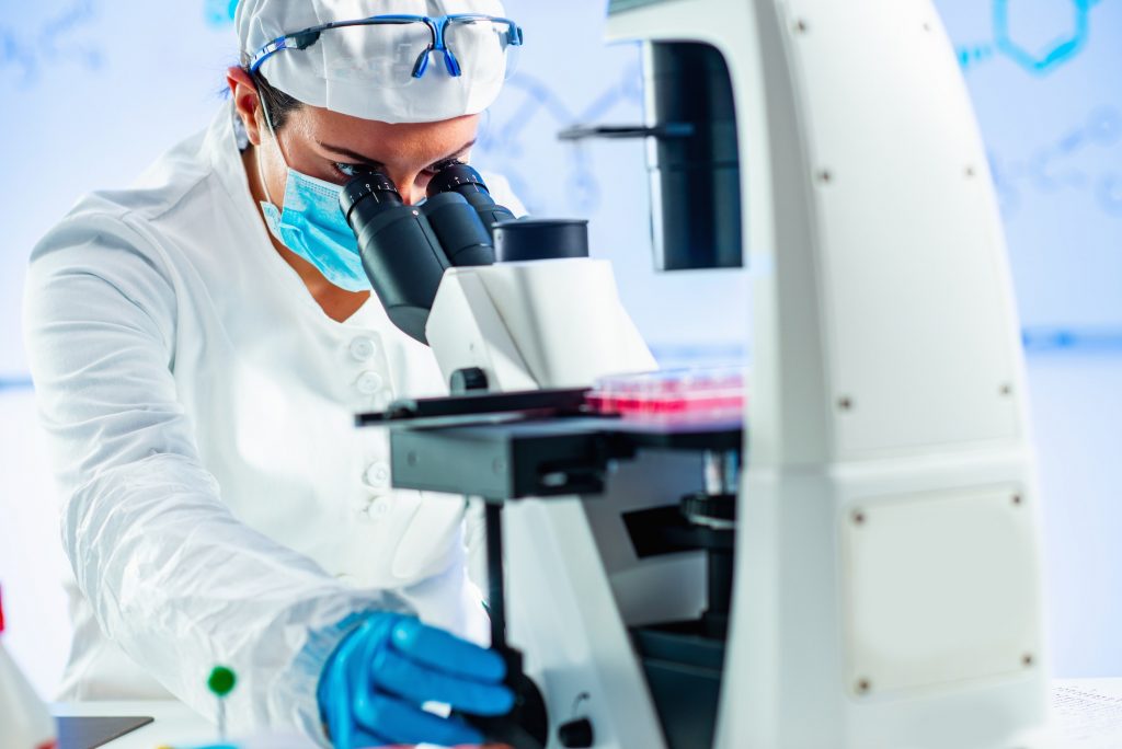 Biology researcher looking through microscope